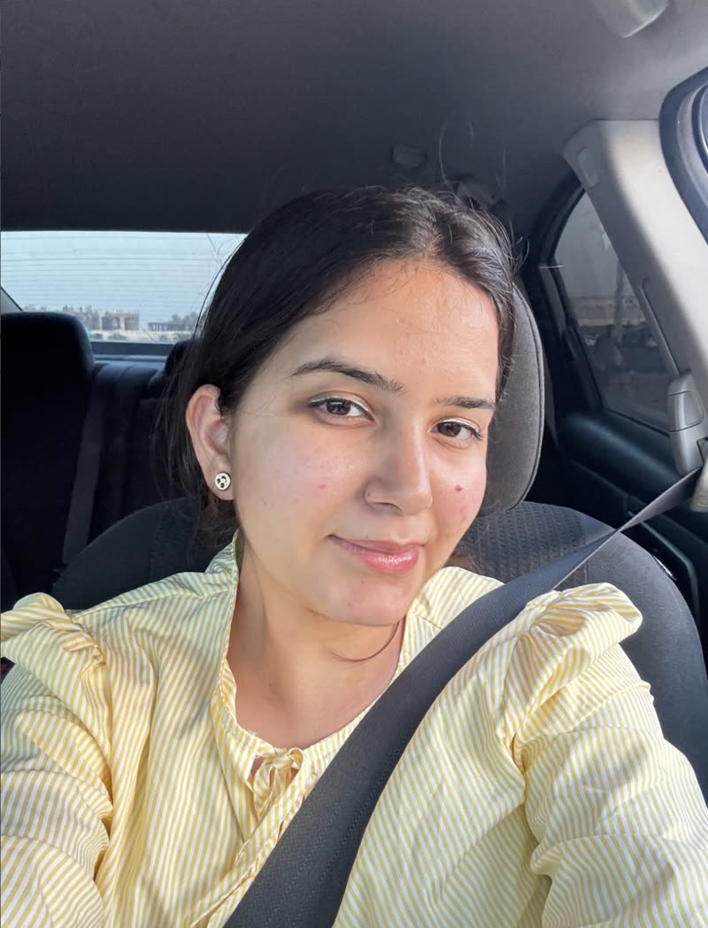 Tushita smiling, wearing a yellow striped blouse